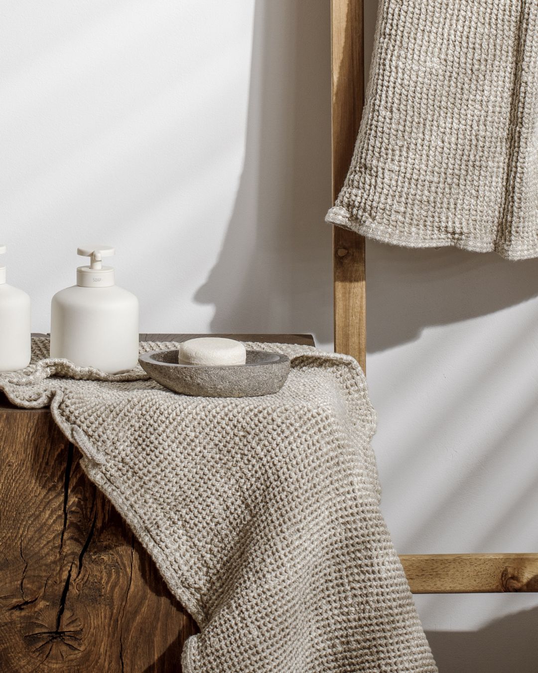 Linge de bain en nid d'abeille et savon sur une console en bois